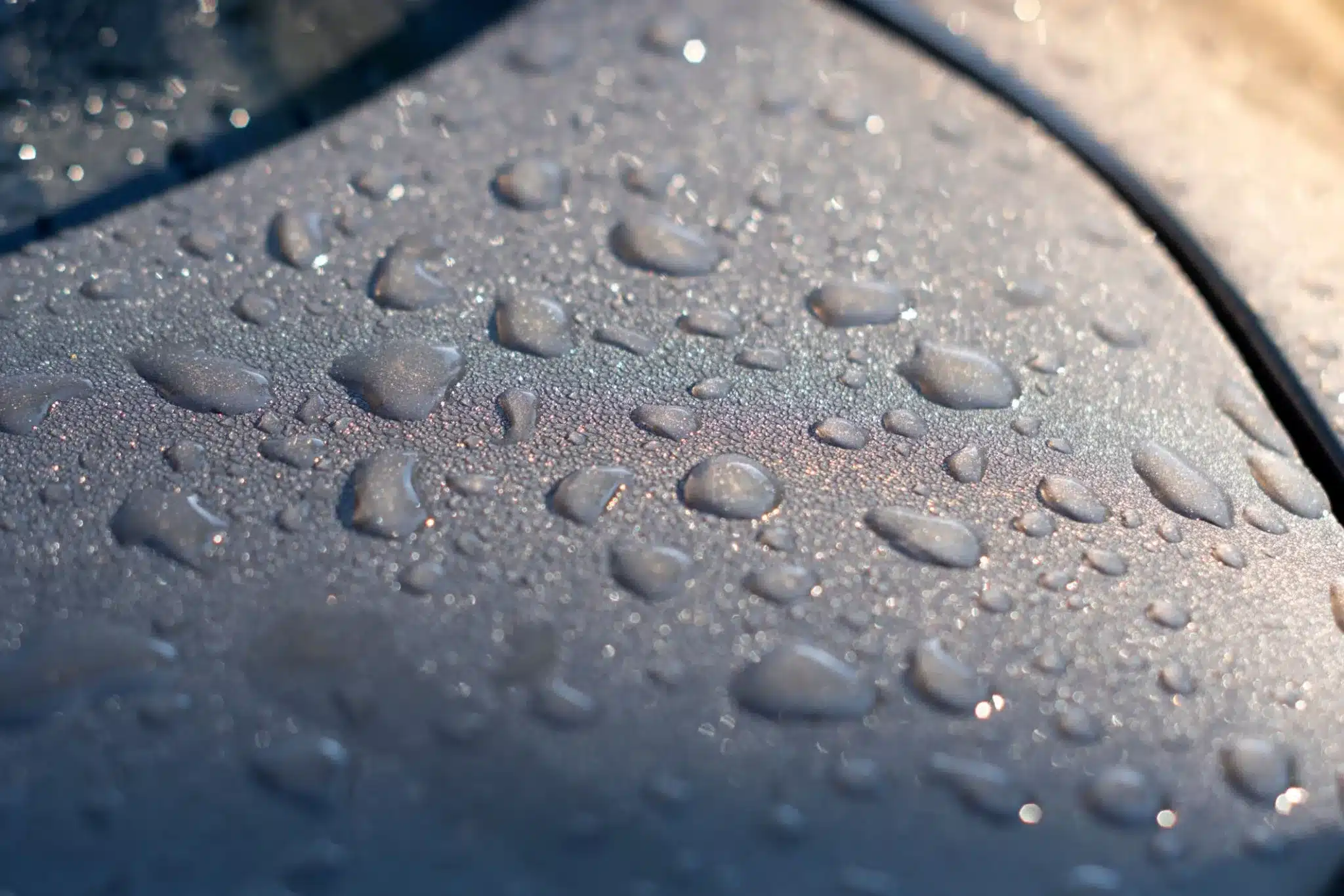 The Ultimate Guide to Finding the Best Graphene Coating for Cars 248 Dramatic close-up of water beading perfectly on a coated car surface, with droplets forming perfect spheres