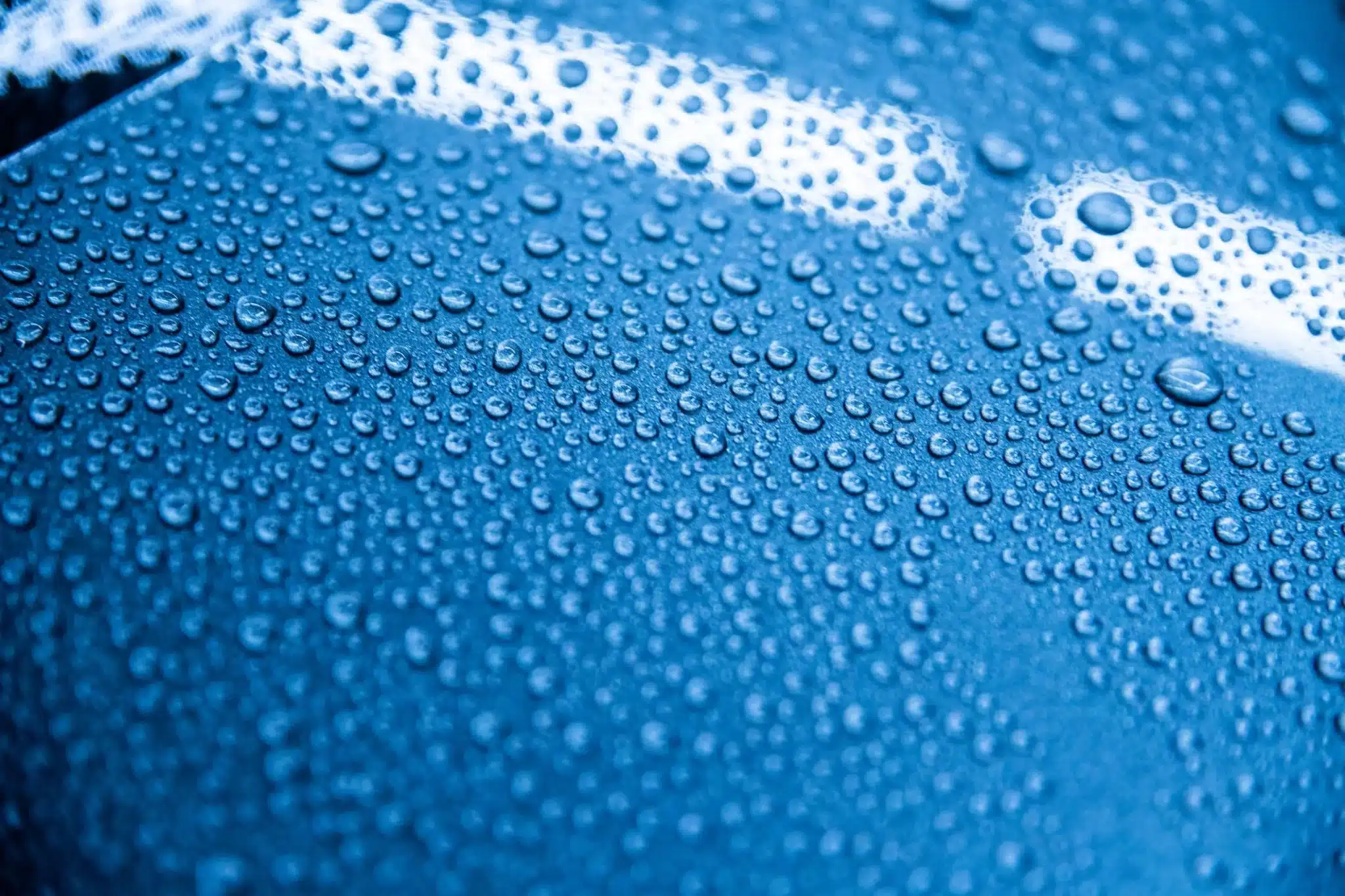 Pre-Sale Car Detailing Sydney | Increase Your Car's Value 167 Dramatic close-up of water beading perfectly on ceramic-coated car paint surface, showcasing protective properties and hydrophobic effect